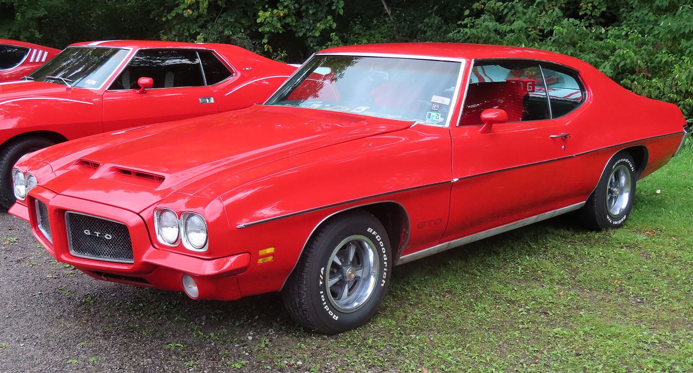 Red 1971 GTO hardtop with its mesh-grille Endura nose and hood scoops, front three-quarter on grass