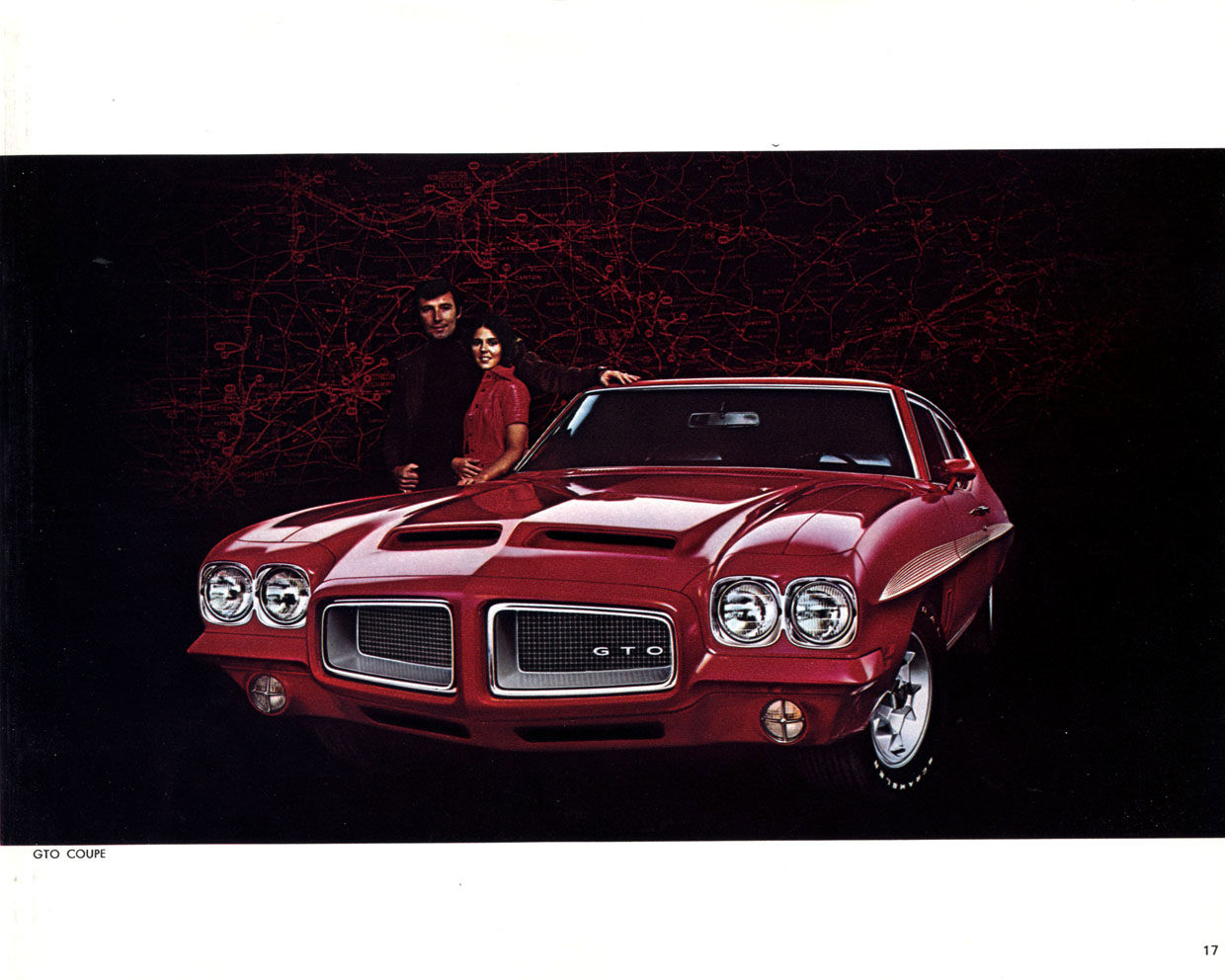 Red 1972 GTO coupe with GTO grille lettering and twin round headlamps, a couple standing behind it