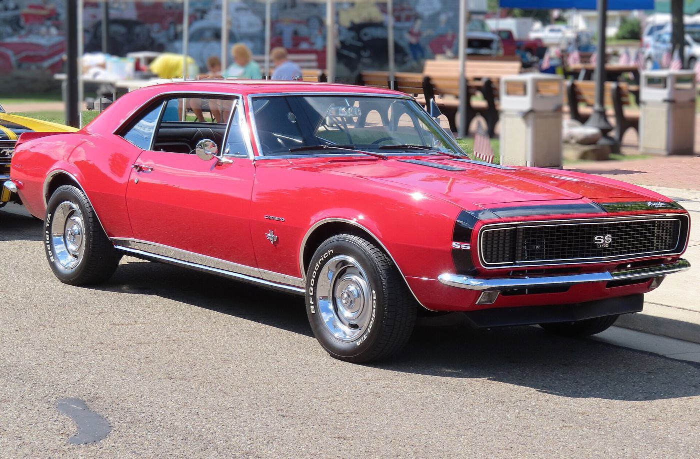 Red 1967 Chevrolet Camaro SS 350 with a black nose stripe, SS grille badge and hidden headlamps, front three-quarter