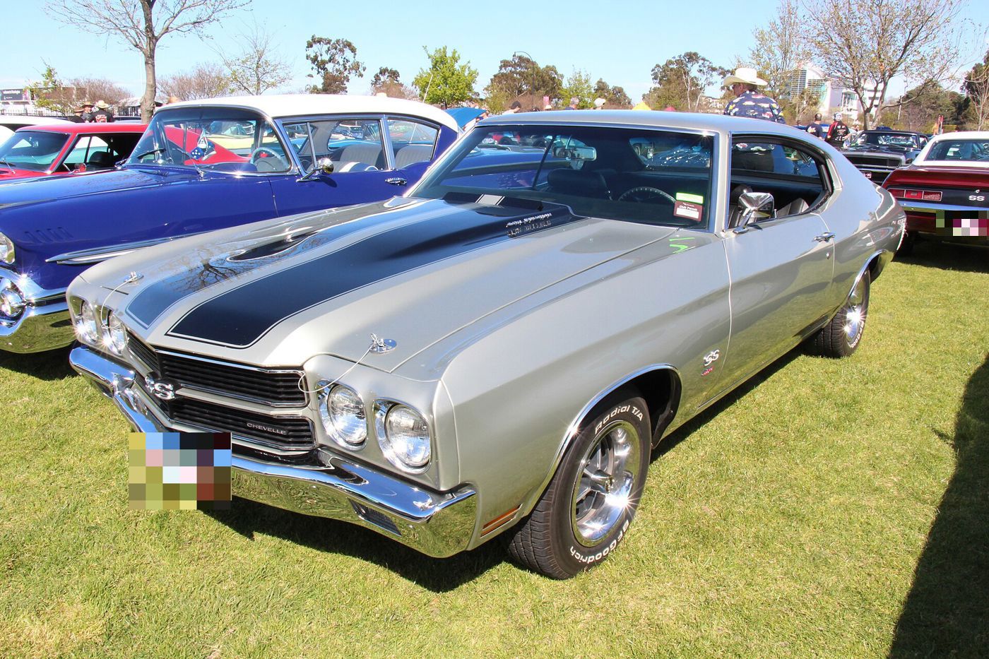 Silver 1970 Chevelle SS hardtop with black hood stripes and SS grille, front three-quarter on grass