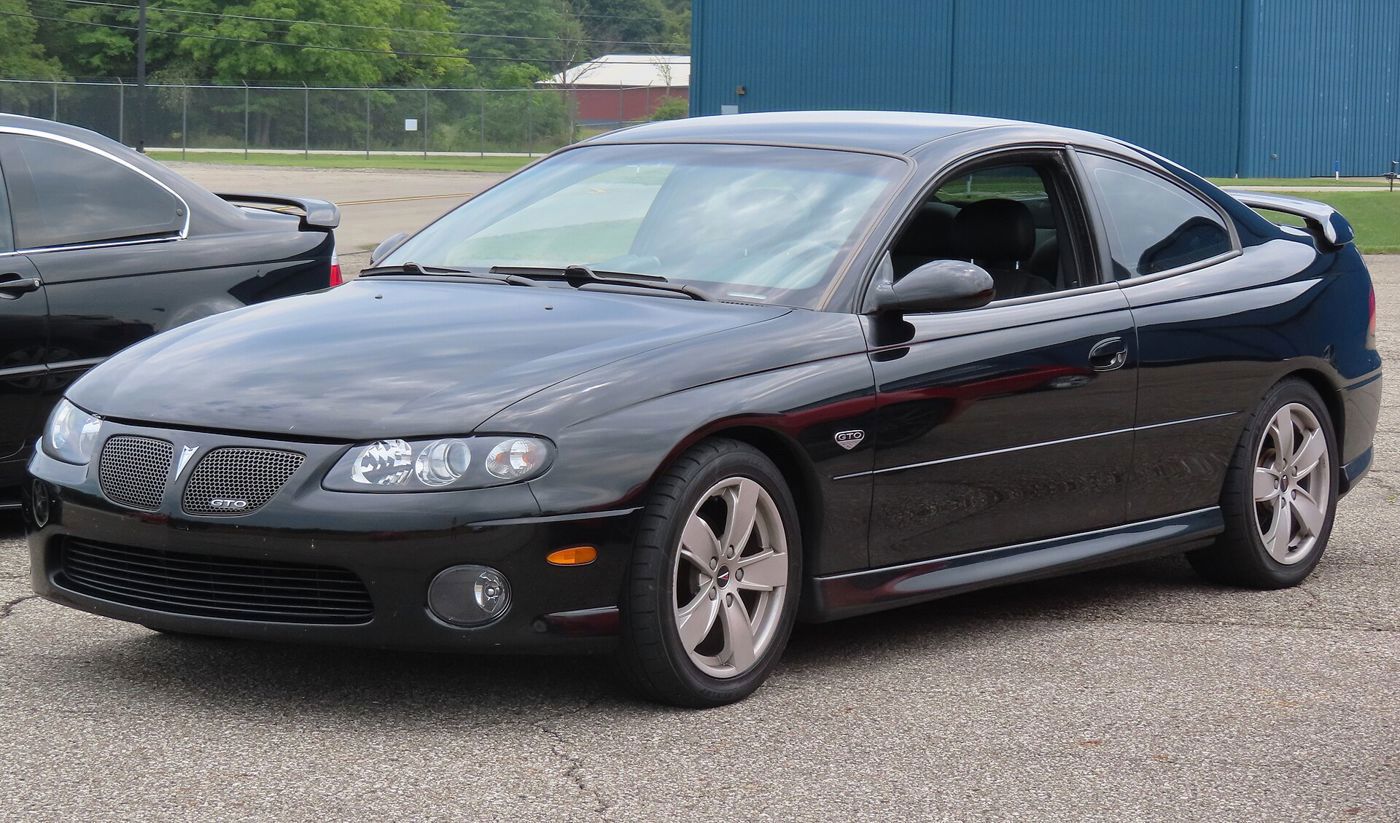 Black 2004 Pontiac GTO coupe with GTO grille badge and five-spoke wheels, front three-quarter on pavement