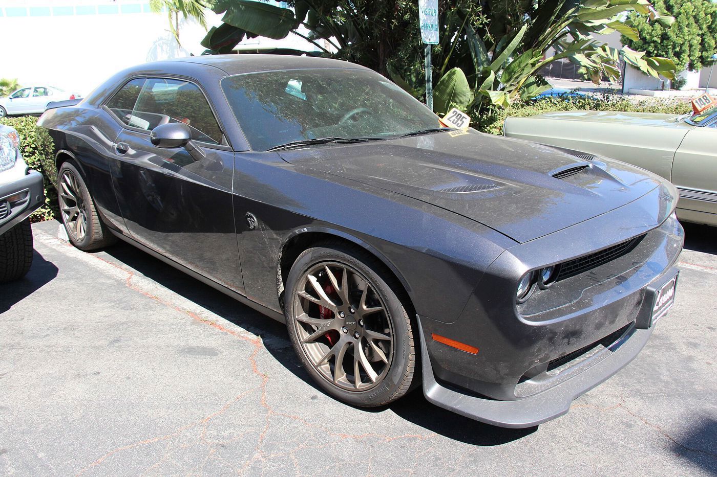 Dark gray 2015 Challenger SRT Hellcat with vented hood and forged wheels, front three-quarter in a parking lot