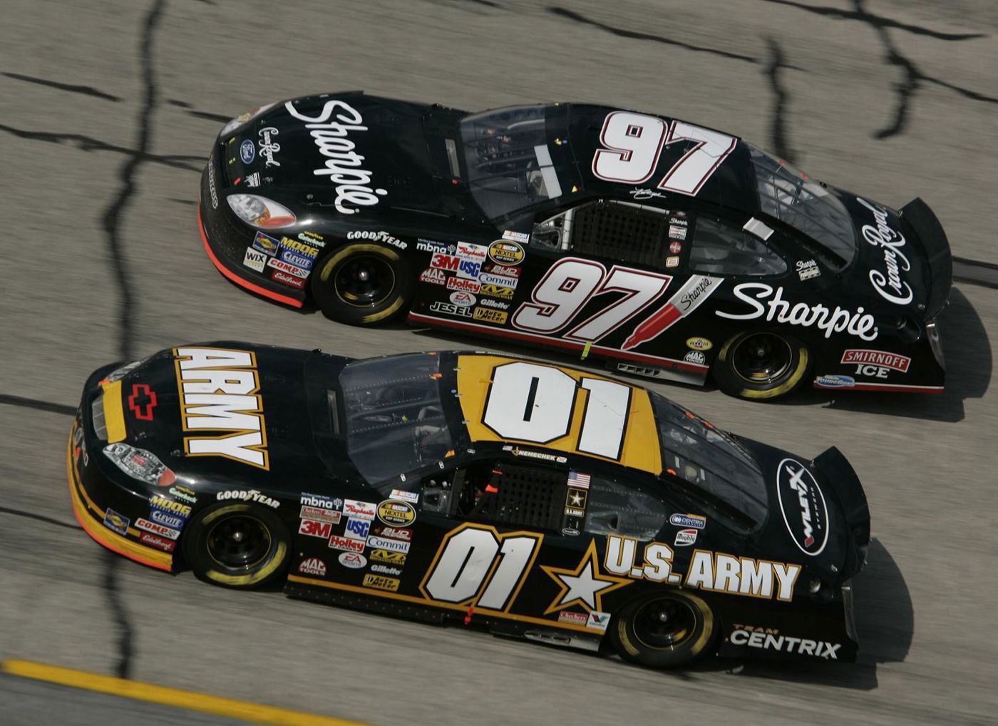 Overhead view of the black number 97 Sharpie Ford racing side by side with the black number 01 Army Chevrolet