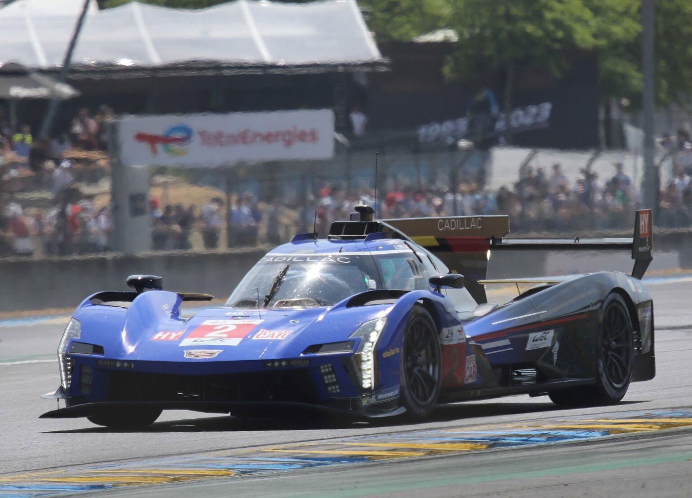 Blue and black Cadillac V-Series.R prototype number 2 exiting the Dunlop chicane with a crowd behind
