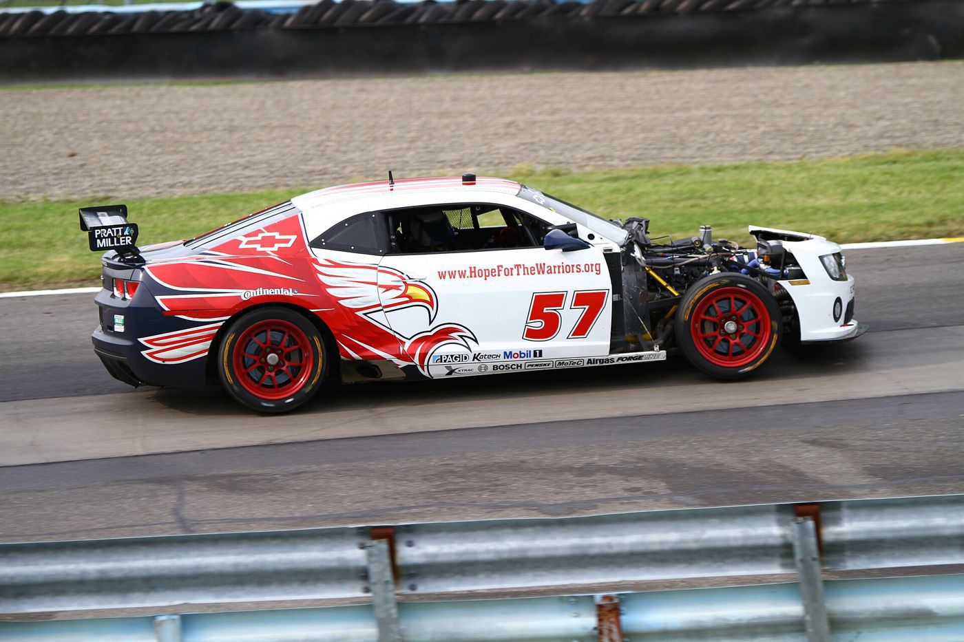 White and red number 57 Camaro GT.R race car on track with its front bodywork missing
