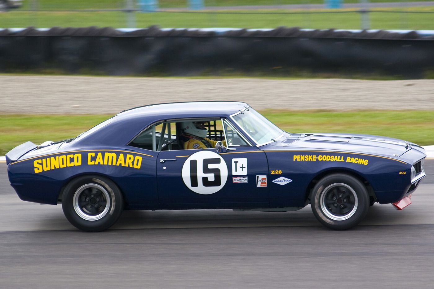 Dark blue Camaro race car with yellow Sunoco Camaro lettering and number 15 on track