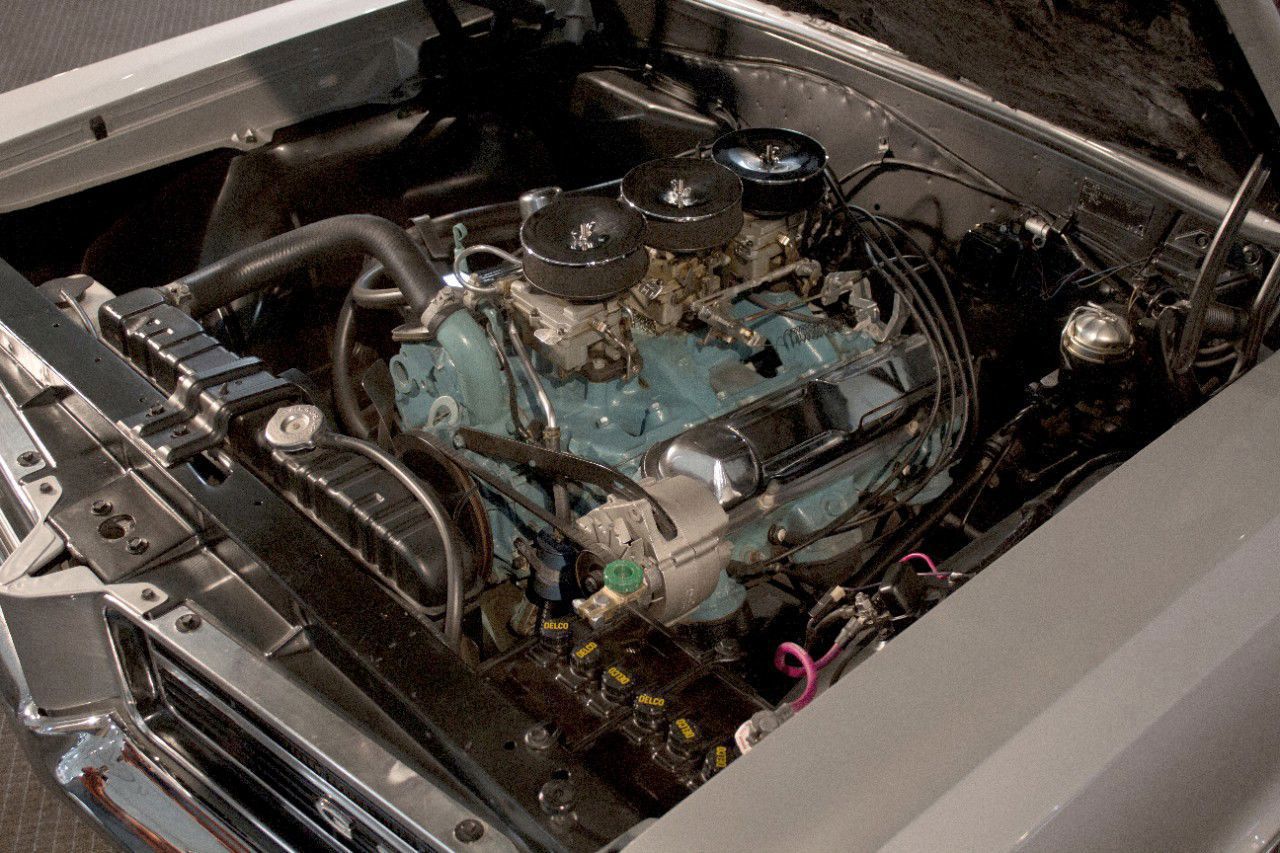Blue Pontiac 389 V8 in a 1964 GTO with three two-barrel carburetors under chrome-lidded air cleaners