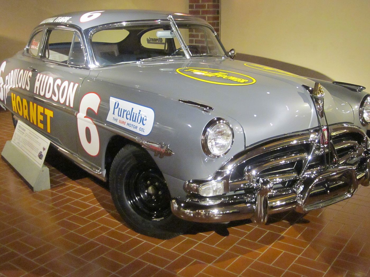 Gray Hudson Hornet race car with Fabulous Hudson Hornet lettering, number 6 and Purelube decal, on museum tile